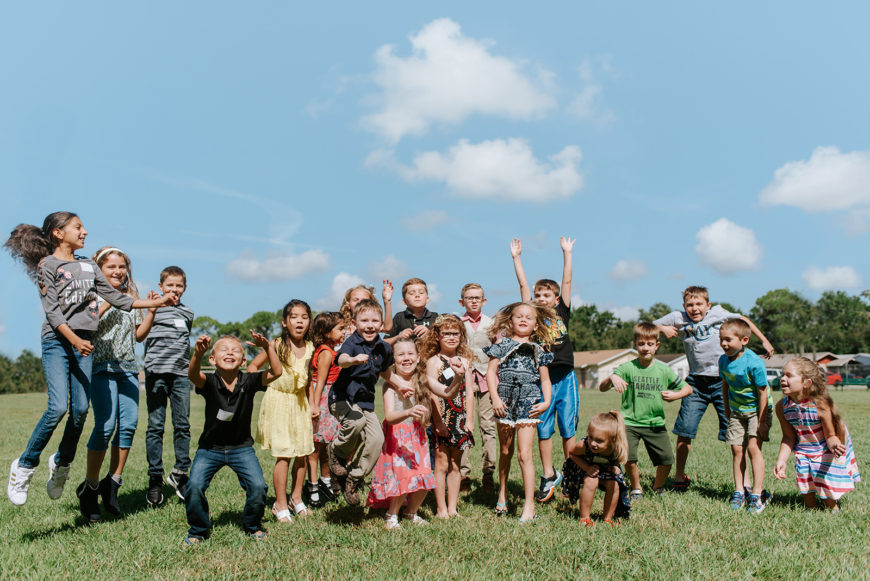 Children smiling together outside at Oasis Kids